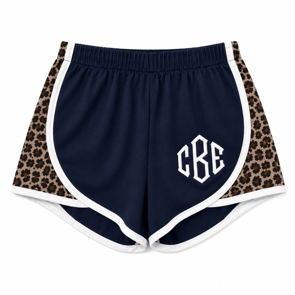 Navy blue athletic shorts with leopard print side panels and white CBE logo